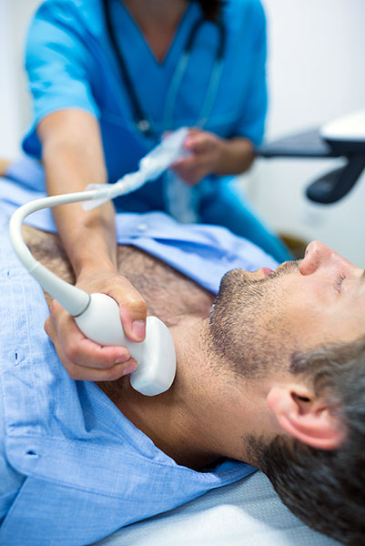 Man getting ultrasound of a thyroid from doctor in hospital