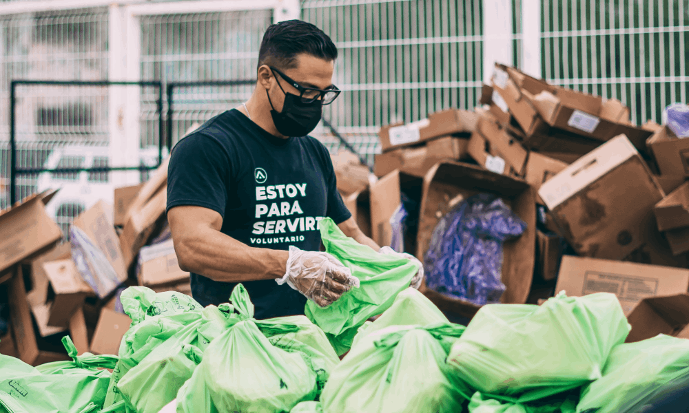 Homem desembrulhando sacolas de mercado em uma ação social
