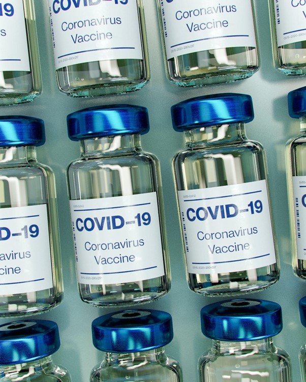 Foto: fracos de vacina dispostos em série. Os recipientes parecem ser de vidro e apresentam o texto “COVID-19 Coronavirus Vaccine”.