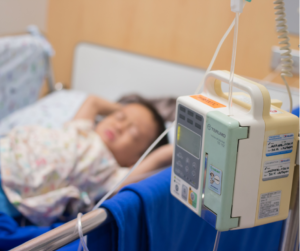 Fotografia de uma criança em uma cama de hospital.