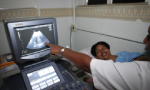Imagem de uma mulher negra grávida fazendo ultrassom