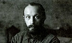 Foto de Mikhail Bakhtin. Foto antiga, um pouco escura e em preto e branco. Mikhail olha diretamente para câmera e tem uma expressão neutra.