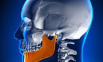 Ilustração de um crânio humano, destacando a mandíbula em uma tonalidade de laranja vibrante.