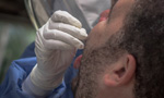 Enfermeiro realizando um teste de Covid-19 em um paciente.