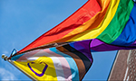 Fotografia de uma bandeira do Orgulho LGBTQIAPN+ hasteada.