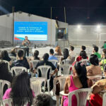 Fotografia de uma apresentação em uma quadra à céu aberto à noite.