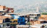 Fotografia de uma cidade, com uma periferia um primeiro plano e de fundo uma parte de cidade com vários prédios